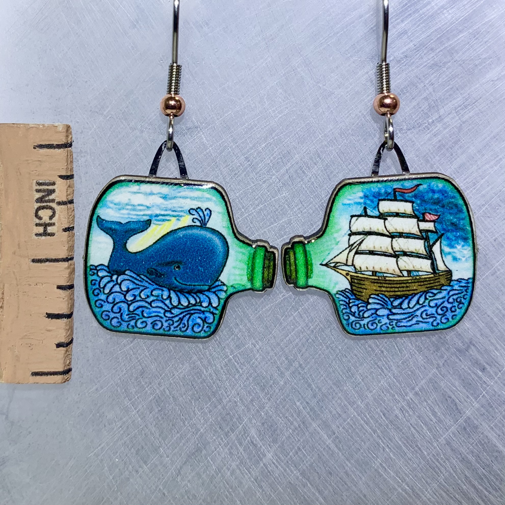 Picture shown is of 1 inch tall pair of earrings of a Whale and a Ship in a bottle.