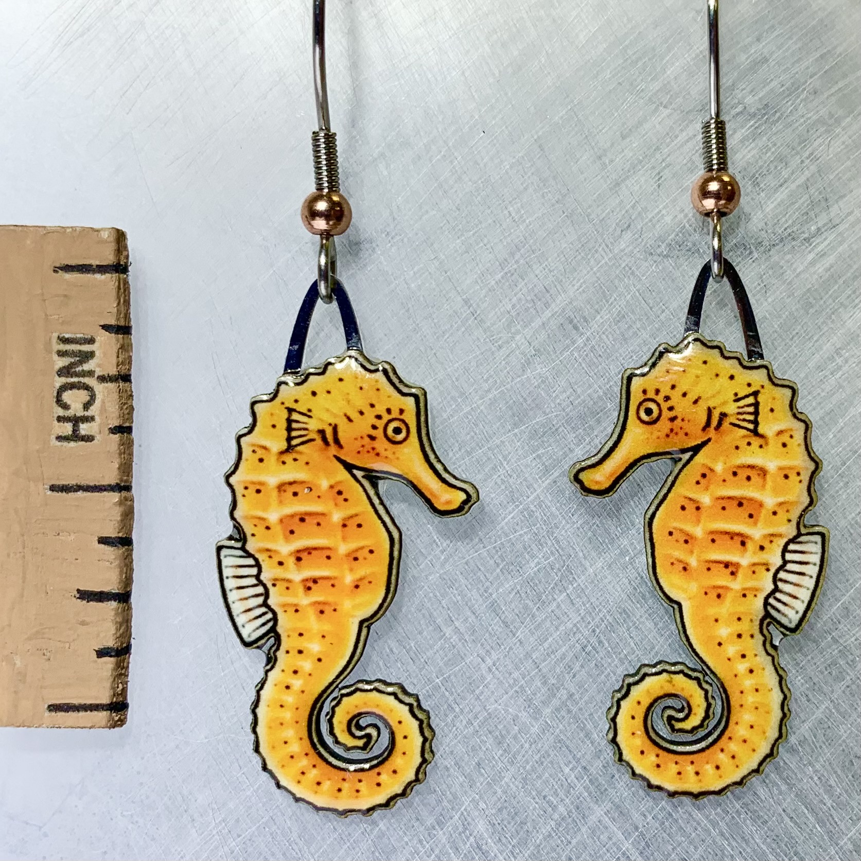 Picture shown is of 1 inch tall pair of earrings of the marine animal the Orange Seahorse.